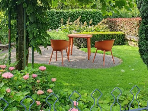 Foto: BGL. - Ein Sitzplatz im hinteren Gartenbereich, ein gekonnt platzierter, schattenwerfender Baum, eine Wegführung, die sich nicht sofort auf einen Blick offenbart = in diesem Garten wurden einige gestalterische Tricks angewendet, um den Garten größer wirken zu lassen.