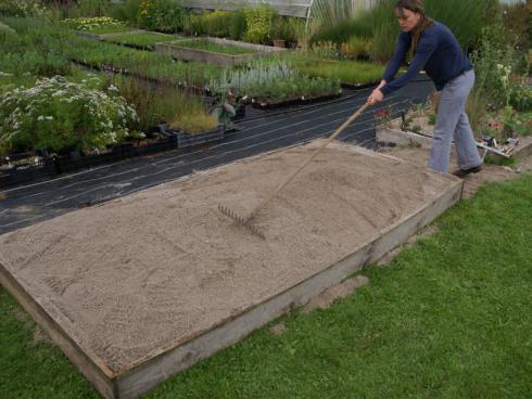 2. Einebnen: Ist genug Sand aufgeschüttet – mindestens 15 cm hoch, da sich der Sand noch setzt – wird die Fläche glattgezogen. Dazu eignet sich die Rechenrückseite sehr gut. (Bildnachweis: GMH/Till Hofmann)